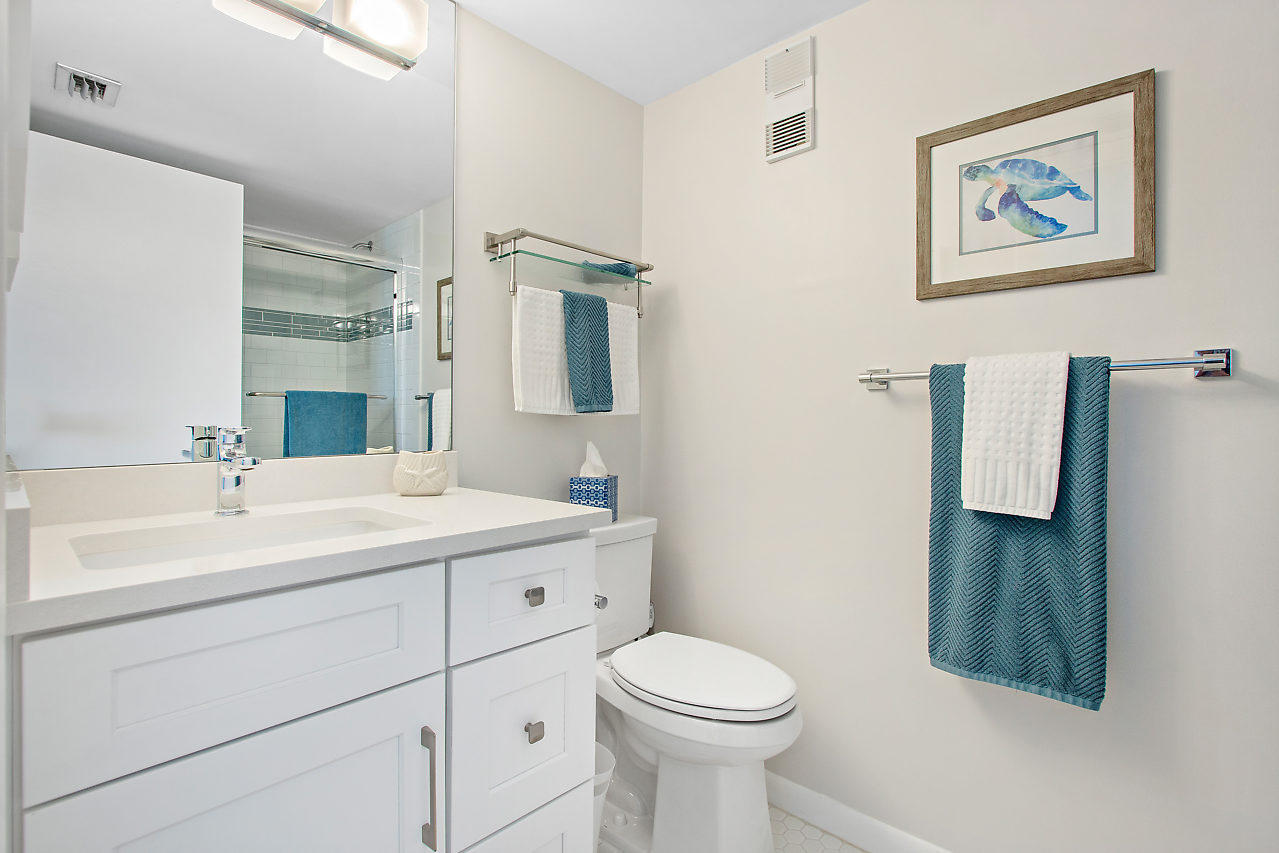 353 Highway 1, Unit B301 Jupiter, FL 33477 - Photo 27 of 58 a bathroom with a toilet sink vanity and mirror