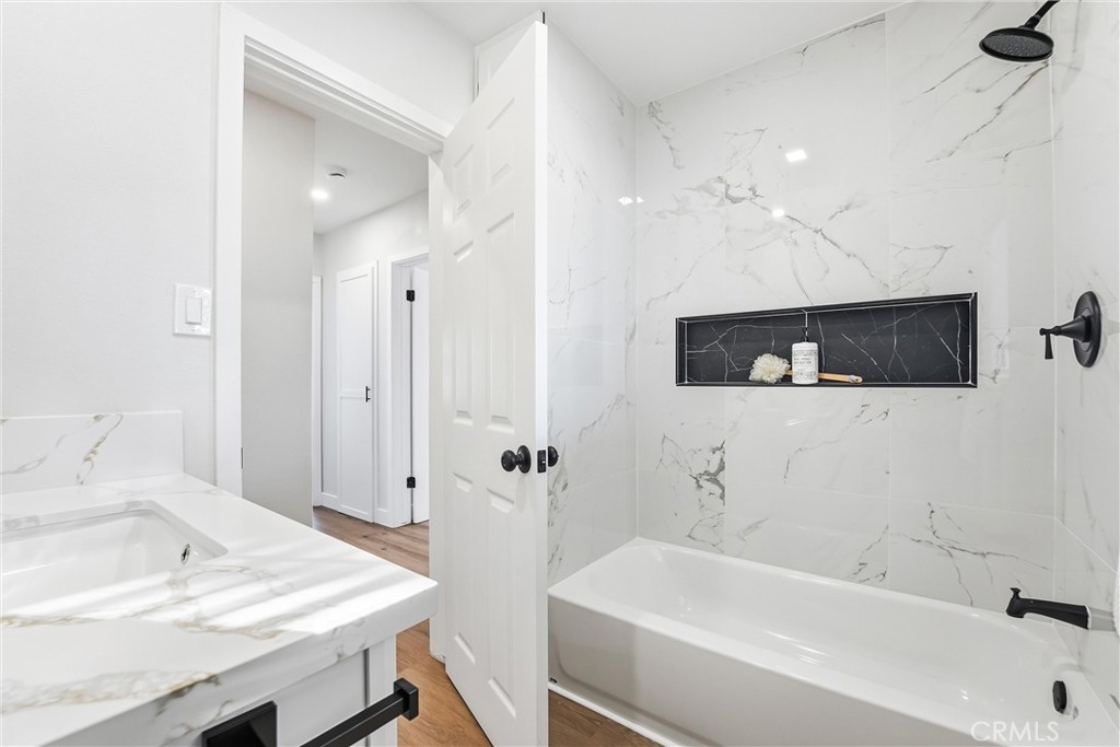 2835 Delta Avenue Long Beach, CA 90810 - Photo 15 of 29 a bathroom with a sink a mirror and a bathtub