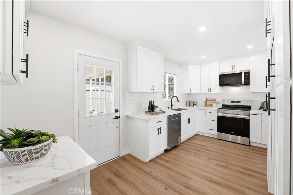 2835 Delta Avenue Long Beach, CA 90810 - Photo 9 of 29 a kitchen with a white stove top oven and white cabinets