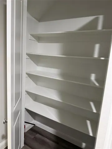a view of walk in closet with empty racks