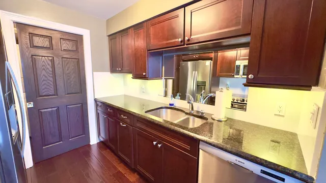 a bathroom with a granite countertop double vanity and a mirror
