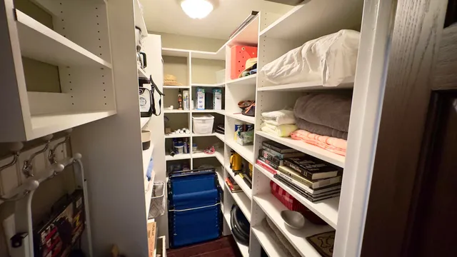 a view of walk in closet with clothes and shoes