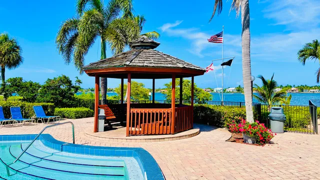 a view of swimming pool with lawn chairs and plants