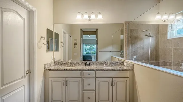 a bathroom with a granite countertop sink and a mirror