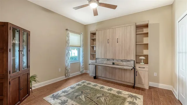an empty room with wooden floor closet and windows