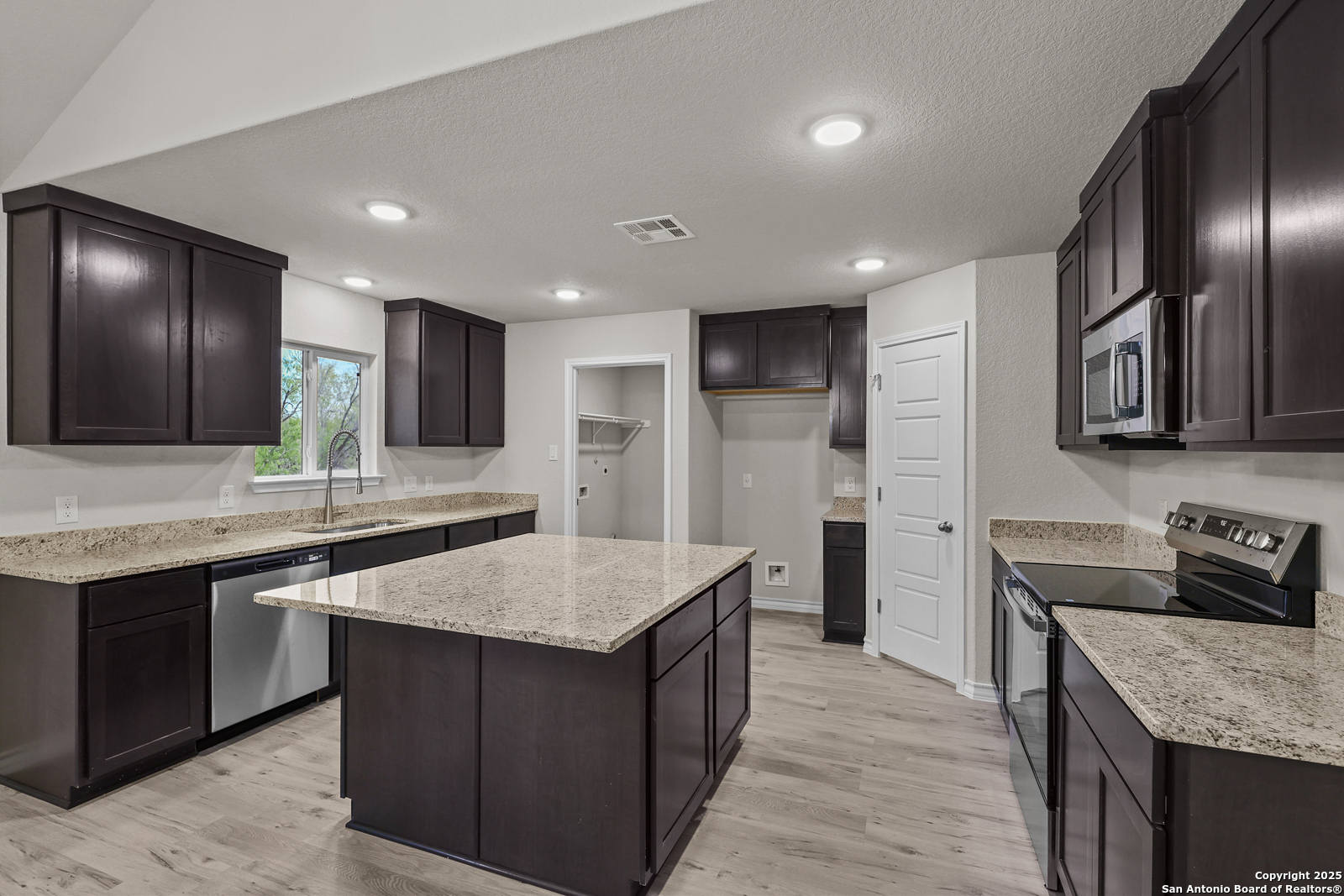 149 Sylas Hayes Loop Pleasanton, TX 78064 - Photo 11 of 38 a kitchen with stainless steel appliances granite countertop wooden cabinets a sink and dishwasher