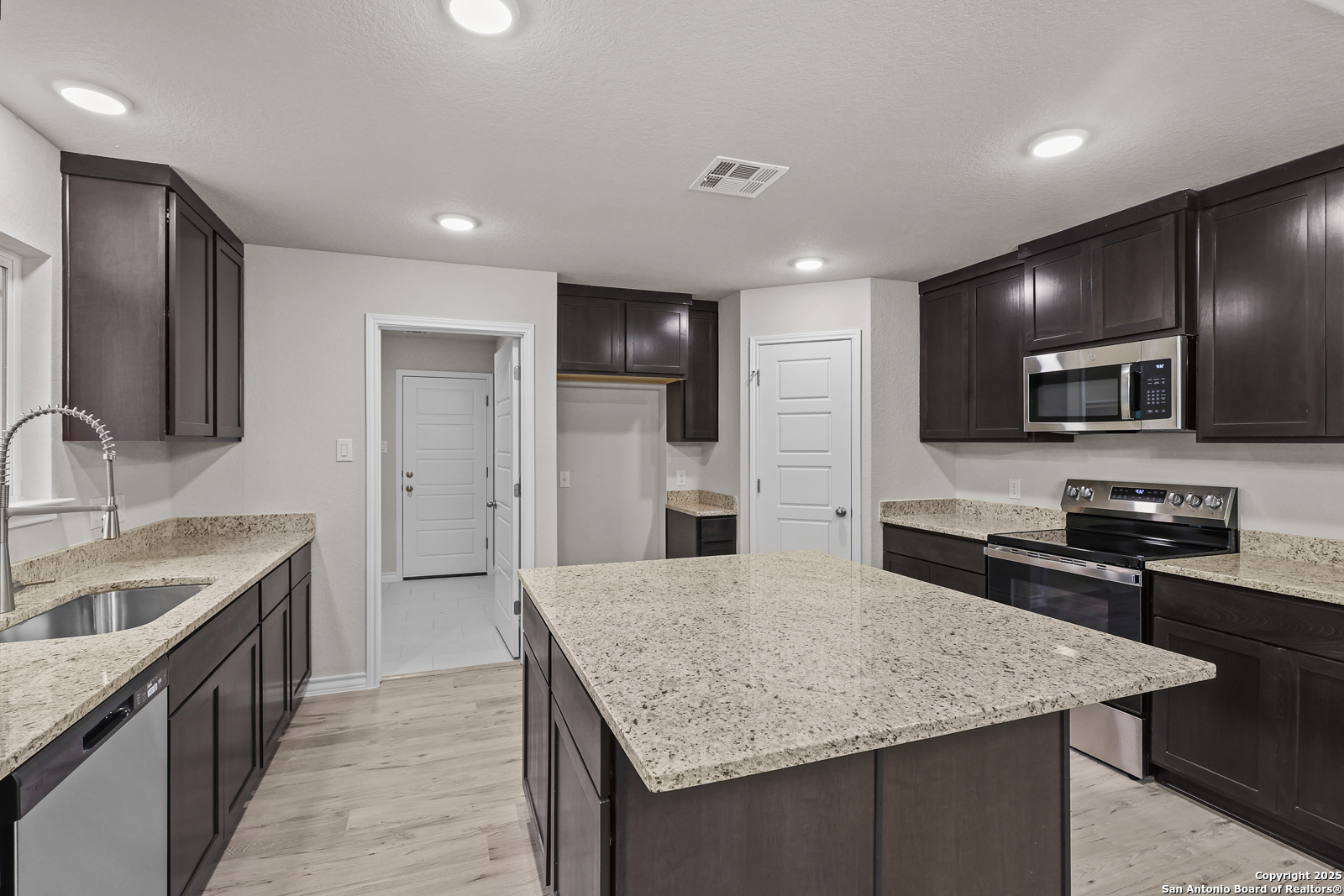 149 Sylas Hayes Loop Pleasanton, TX 78064 - Photo 13 of 38 a kitchen with a center island appliances and cabinets