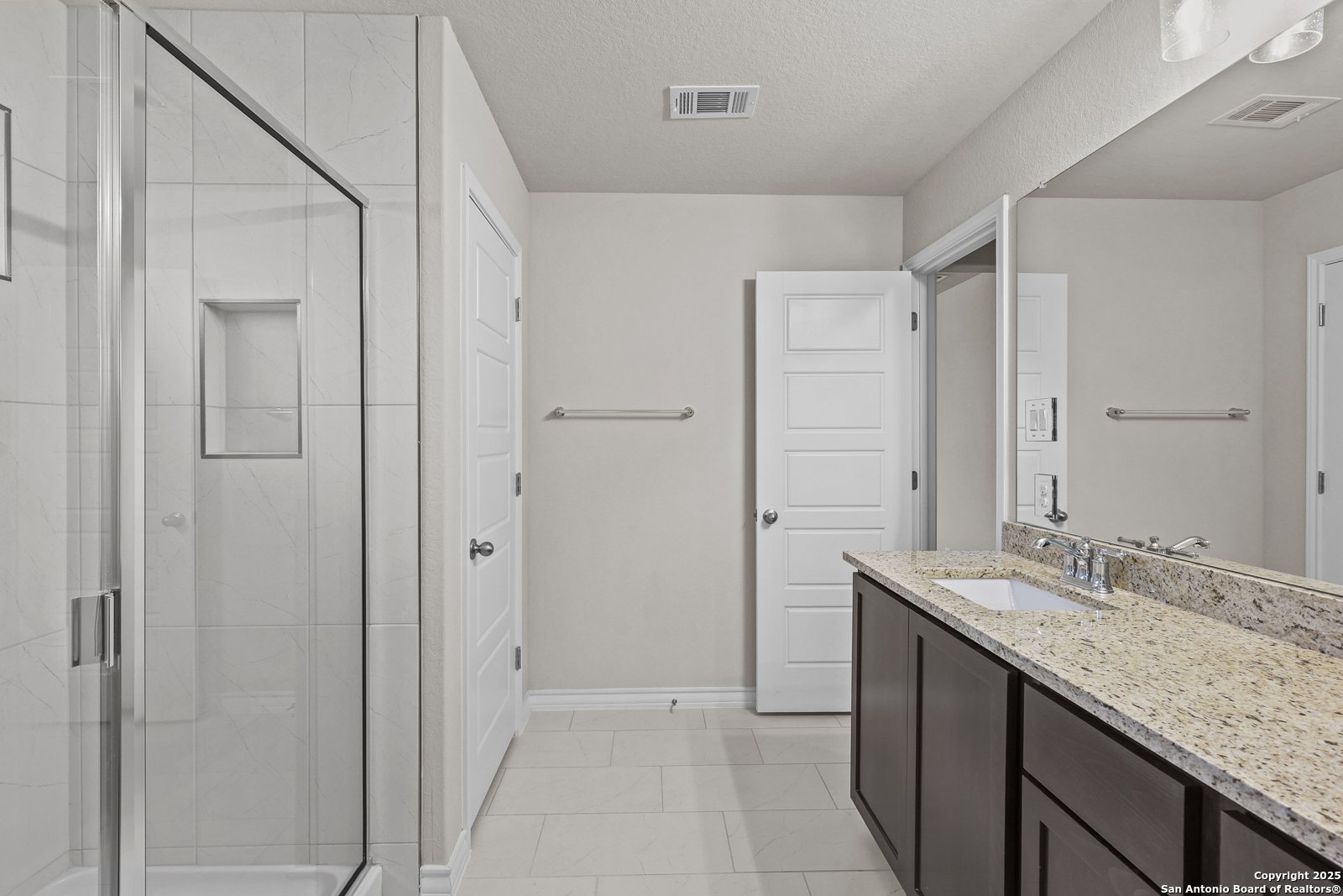 149 Sylas Hayes Loop Pleasanton, TX 78064 - Photo 22 of 38 a bathroom with a granite countertop sink two mirror and a shower