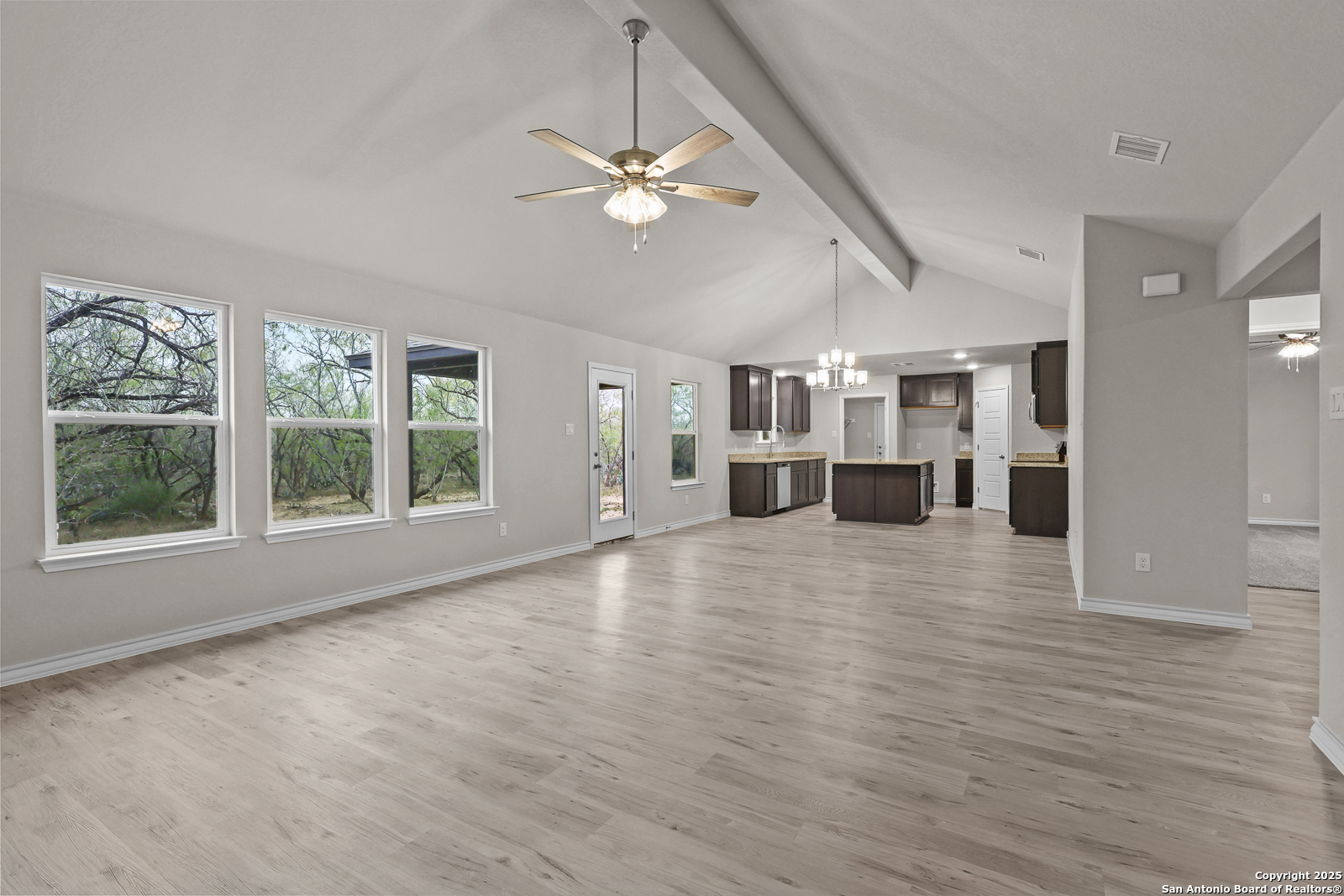 149 Sylas Hayes Loop Pleasanton, TX 78064 - Photo 10 of 38 a view of an empty room with a window and wooden floor