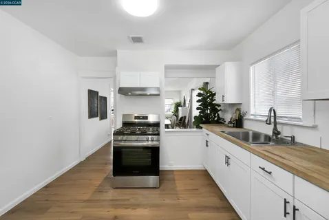 a kitchen with white cabinets and appliances