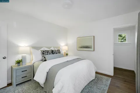 a bedroom with a bed and a lamp on dresser
