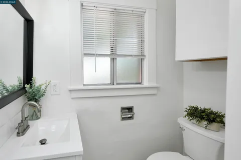 a bathroom with a sink toilet and a mirror