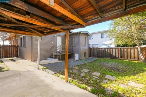 a view of a backyard with wooden fence and a tub