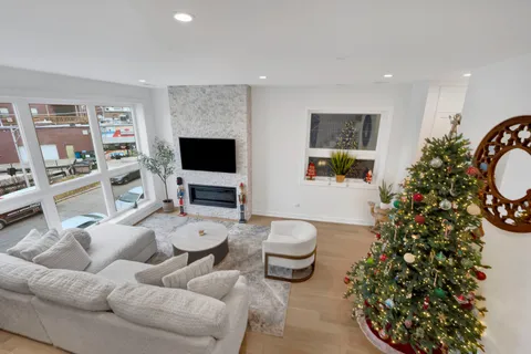 a living room with furniture a flat screen tv and a potted plant
