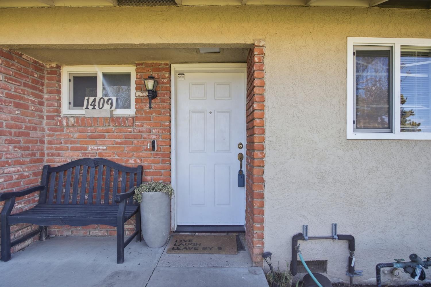 1409 Stonum Road Modesto, CA 95351 - Photo 6 of 40 a brick house with table and chairs