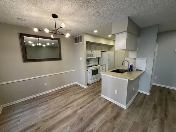 a room with kitchen island stainless steel appliances wooden floor stove and kitchen view