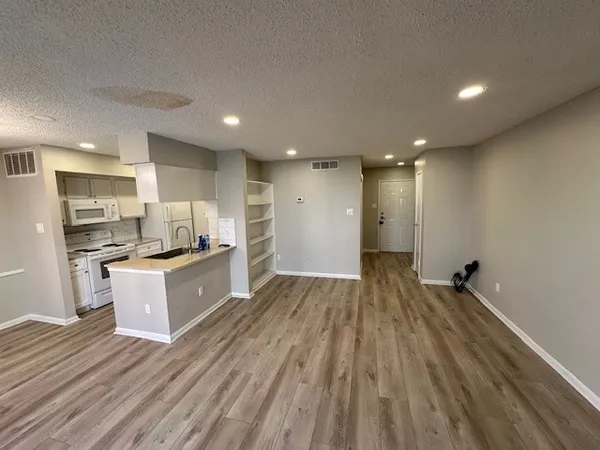 a large kitchen with stainless steel appliances a large counter top and a stove