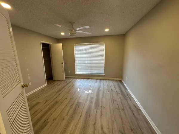 wooden floor in an empty room with a kitchen