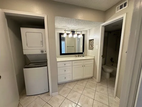 a spacious bathroom with a granite countertop sink and a mirror