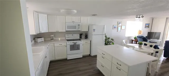 a kitchen with white cabinets and white appliances