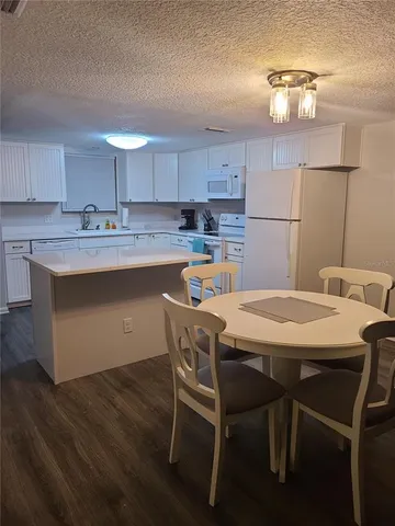 a kitchen with a table chairs stove and cabinets