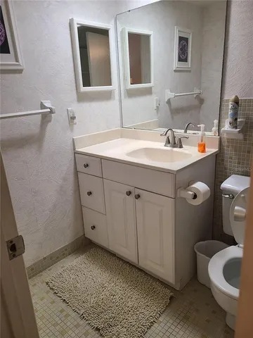 a bathroom with a sink and mirror with toilet