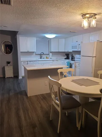 a kitchen with a table chairs stove and cabinets