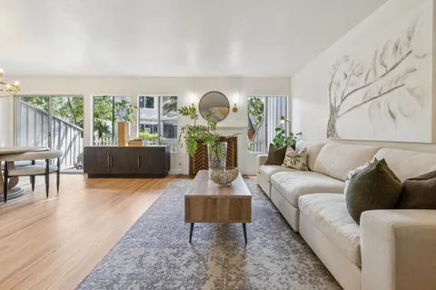 a living room with furniture a potted plant and a fireplace
