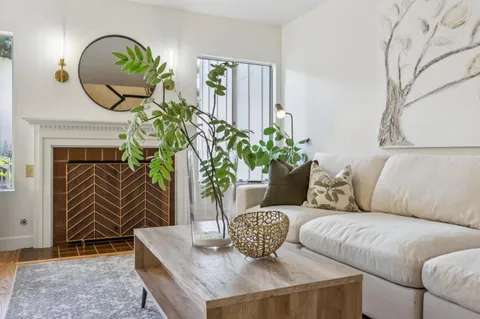 a living room with furniture a fireplace and a large window