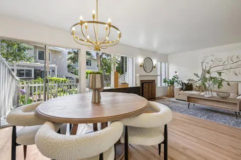 a view of a dining room with furniture a chandelier and wooden floor