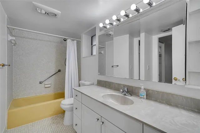 a bathroom with a granite countertop sink a toilet and a bathtub