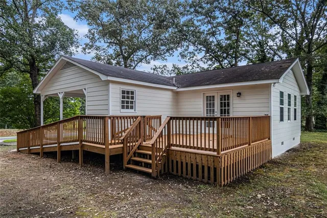 a view of a house with a wooden deck and a yard