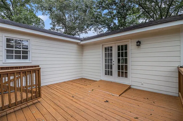 a view of a deck with wooden floor and fence next to a yard