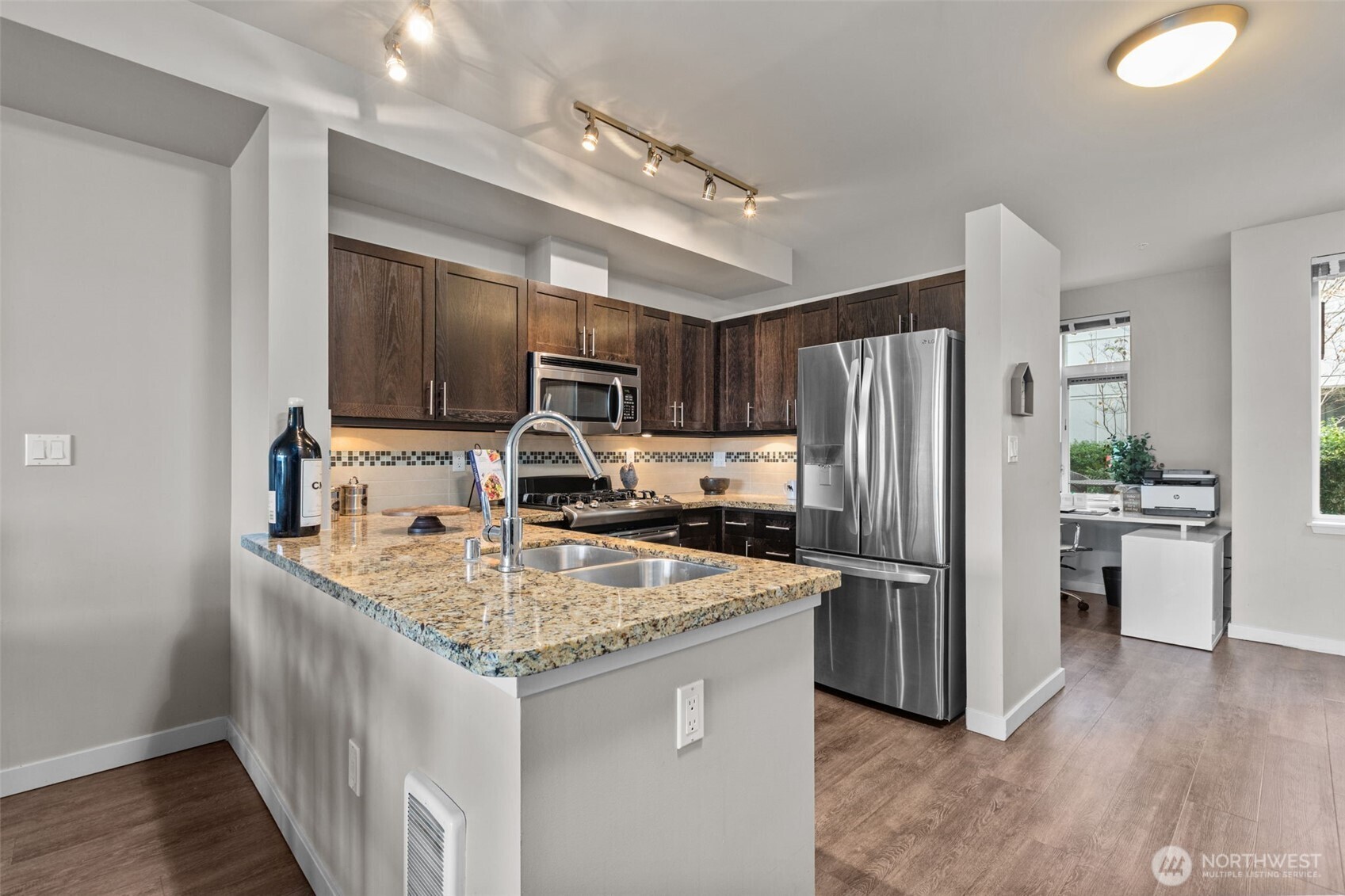 15100 6th Avenue Southwest, Unit 305 Burien, WA 98166 - Photo 12 of 40 a kitchen with kitchen island granite countertop stainless steel appliances a sink stove refrigerator and cabinets