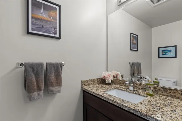 a bathroom with a granite countertop sink and a mirror