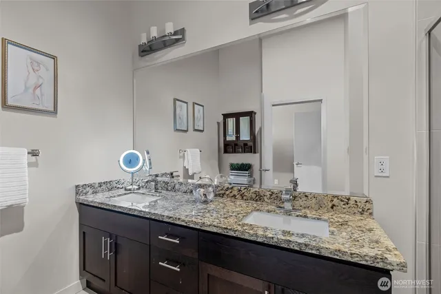 a bathroom with a granite countertop sink and a mirror