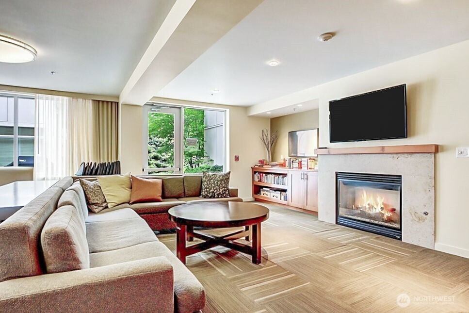 15100 6th Avenue Southwest, Unit 305 Burien, WA 98166 - Photo 35 of 40 a living room with furniture a flat screen tv and a fireplace