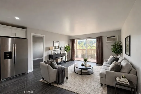 a living room with furniture wooden floor and a large window
