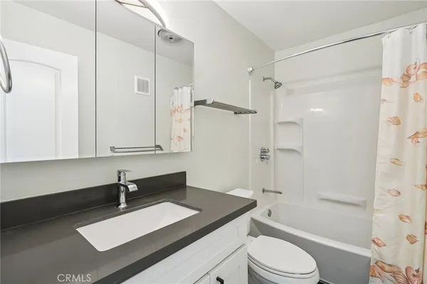 a bathroom with a sink vanity granite toilet tub and shower