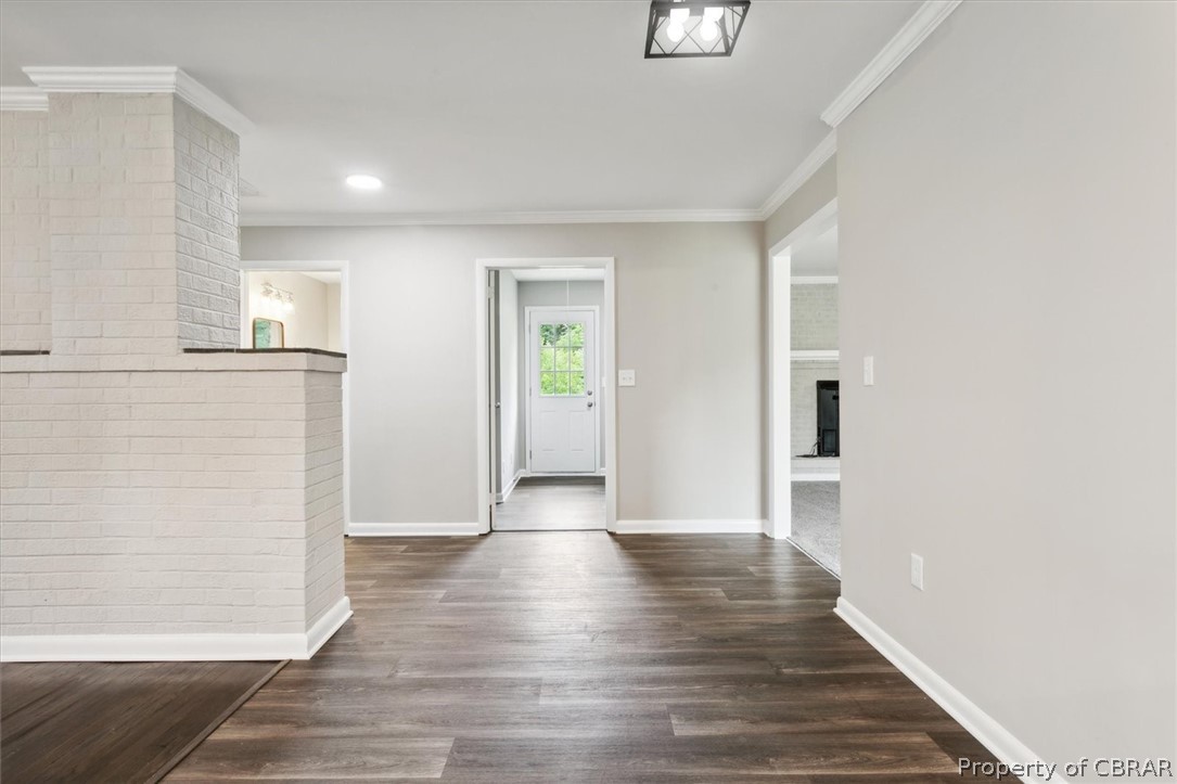 9040 Diascund Road Lanexa, VA 23089 - Photo 10 of 37 Hallway with brick wall, crown molding, and dark hardwood / wood-style flooring