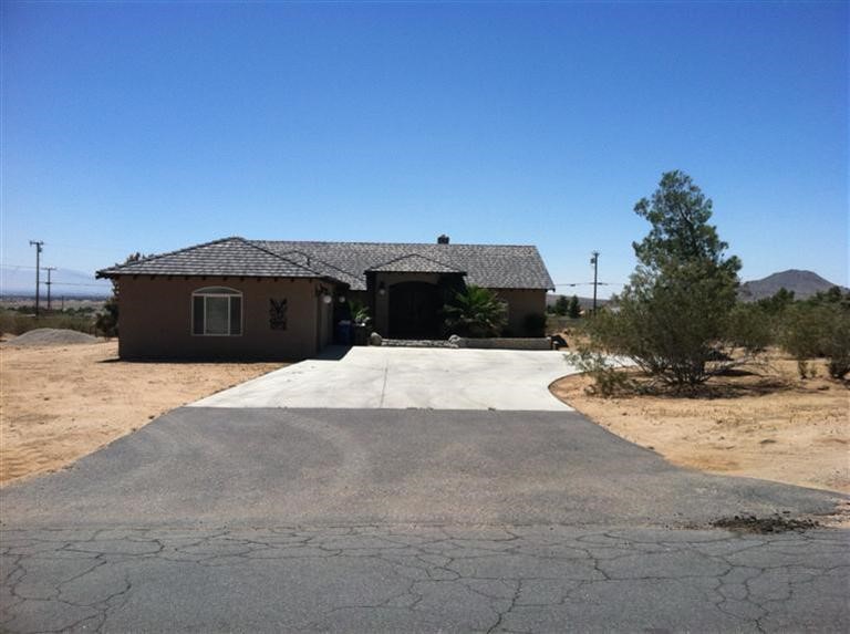 16930 Joshua Road Apple Valley, CA 92307 - Photo 1 of 1 a view of a house with a yard covered with snow in the background