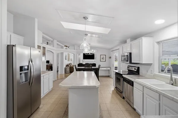 a large kitchen with stainless steel appliances lots of counter space and a refrigerator