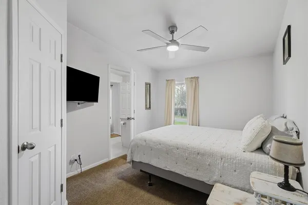 a bedroom with a bed tv and a window