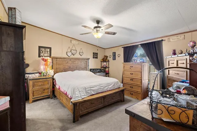 a spacious bedroom with a bed and a chandelier