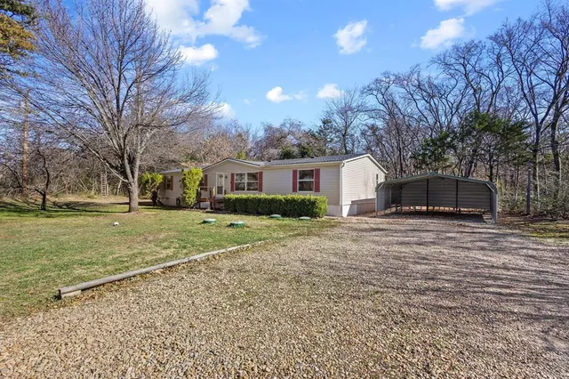 a front view of a house with a yard and trees