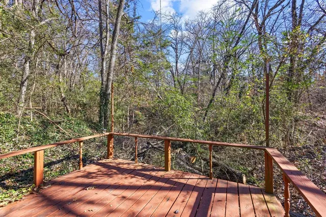 a view of a balcony with wooden floor and fence