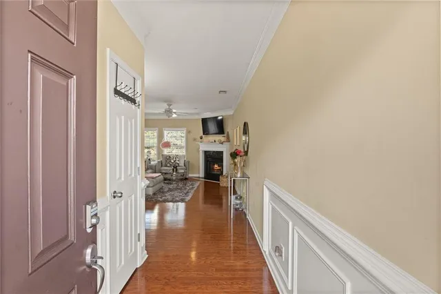 a view of a hallway with wooden floor and a living room