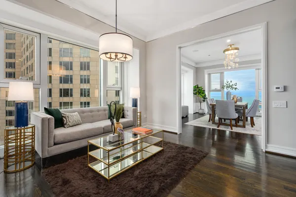 a living room with furniture chandelier and a table