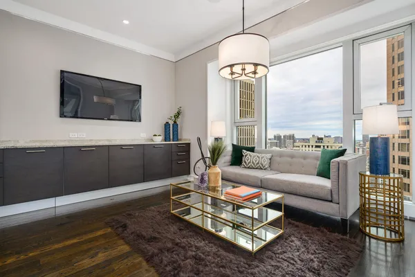 a living room with furniture a large window and a flat screen tv