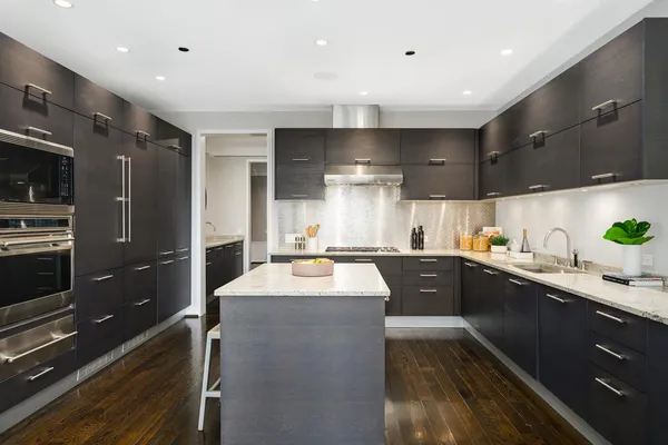 a kitchen with kitchen island granite countertop a sink stainless steel appliances and cabinets